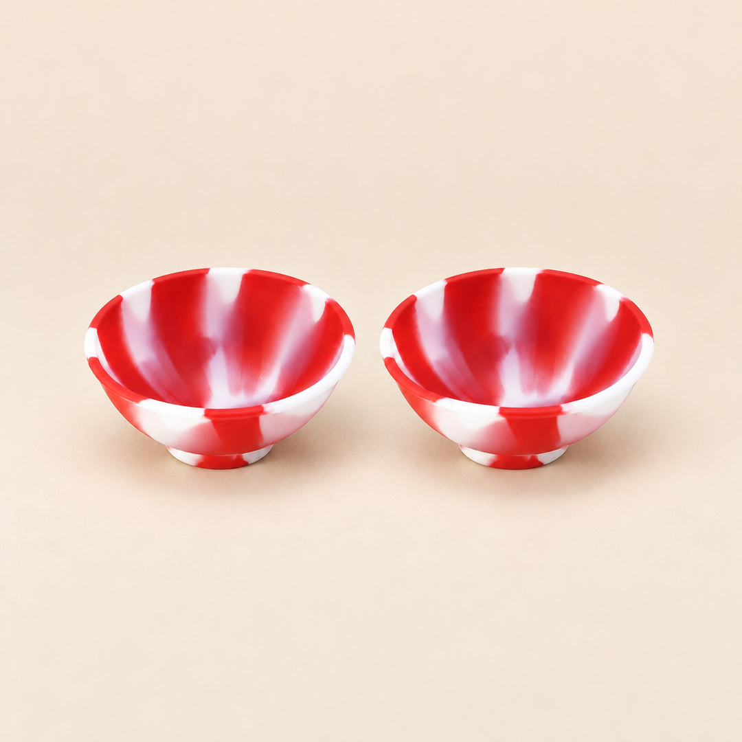 Two red and white swirl silicone mini bowls, open tops and pedestal bases.