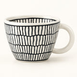 A white ceramic coffee mug with a black hand-drawn vertical stripe pattern, shown on a clean white background.