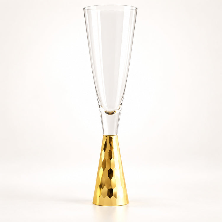 A clear champagne flute with a hammered gold metallic base, photographed against a seamless white background.