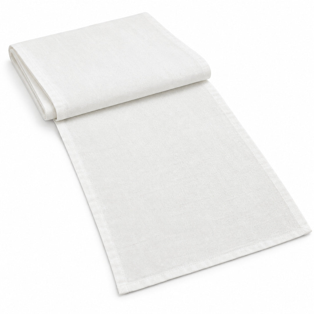 White cotton table runner with sewn edges, folded studio view; choose length separately.