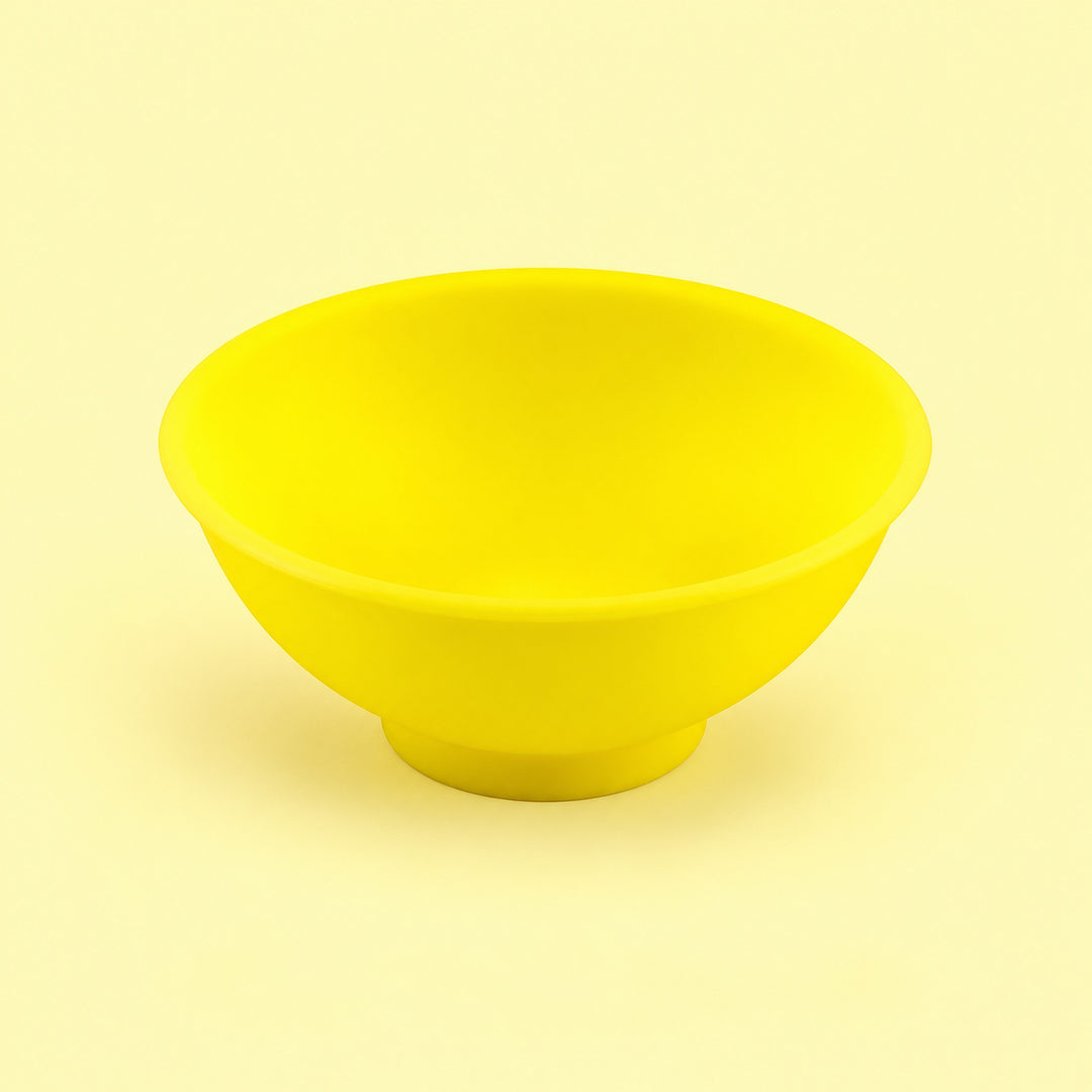 Yellow mini silicone bowl, single empty piece in studio.