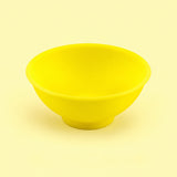 Yellow mini silicone bowl, single empty piece in studio.