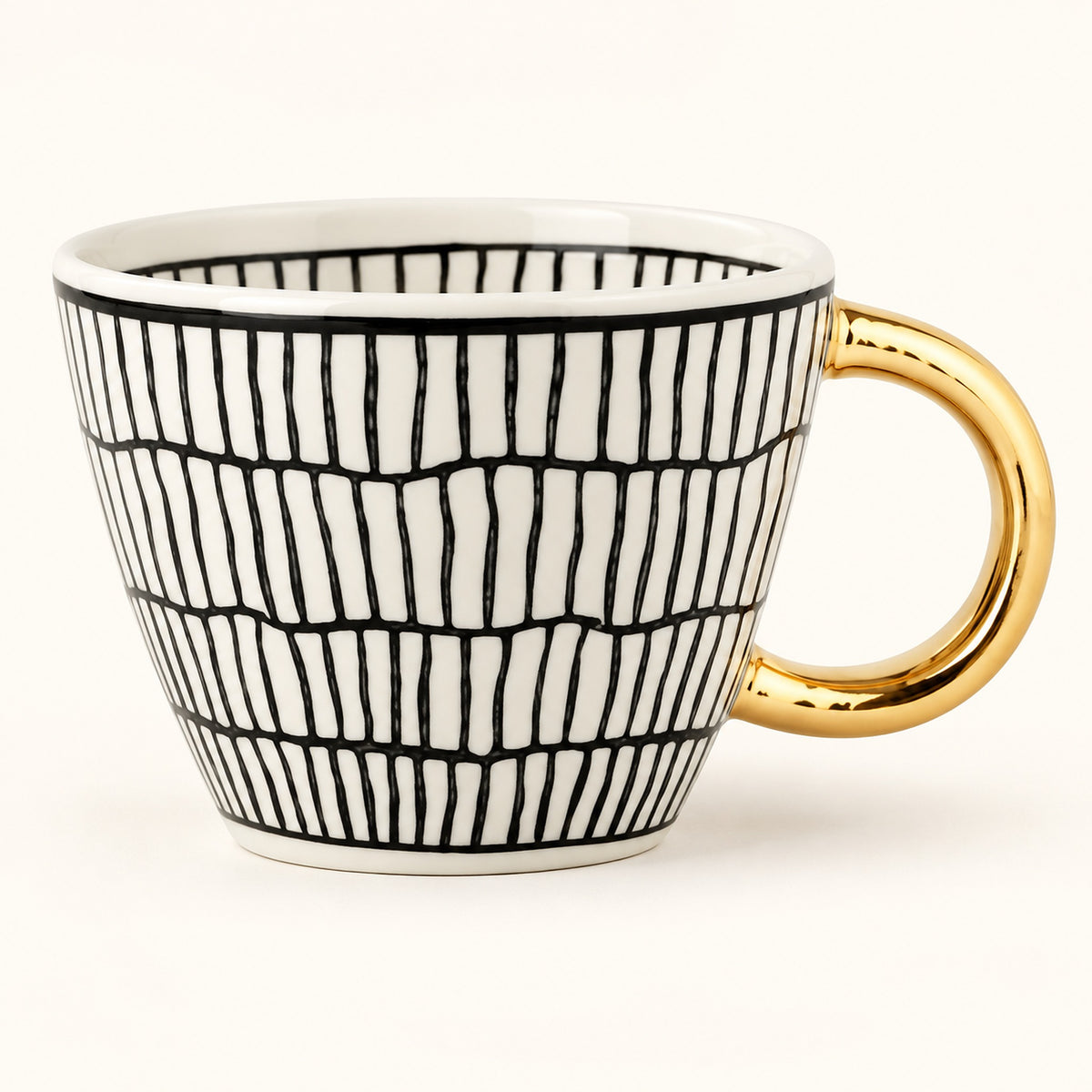 A white ceramic coffee mug with a black hand-drawn vertical line pattern and a shiny gold handle, shown on a clean white background.