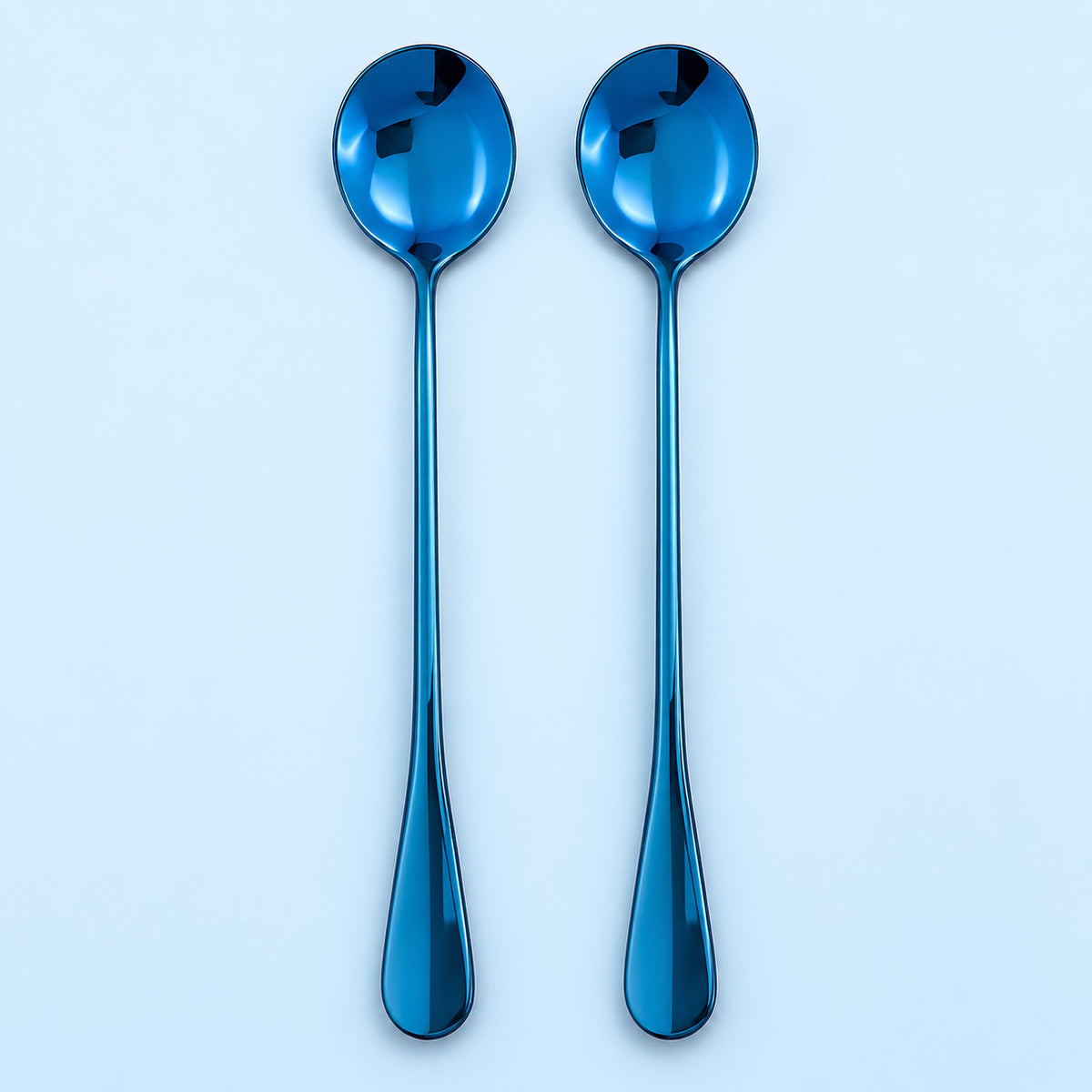 Two metallic blue spoons with long handles, arranged vertically side-by-side on a light blue background.