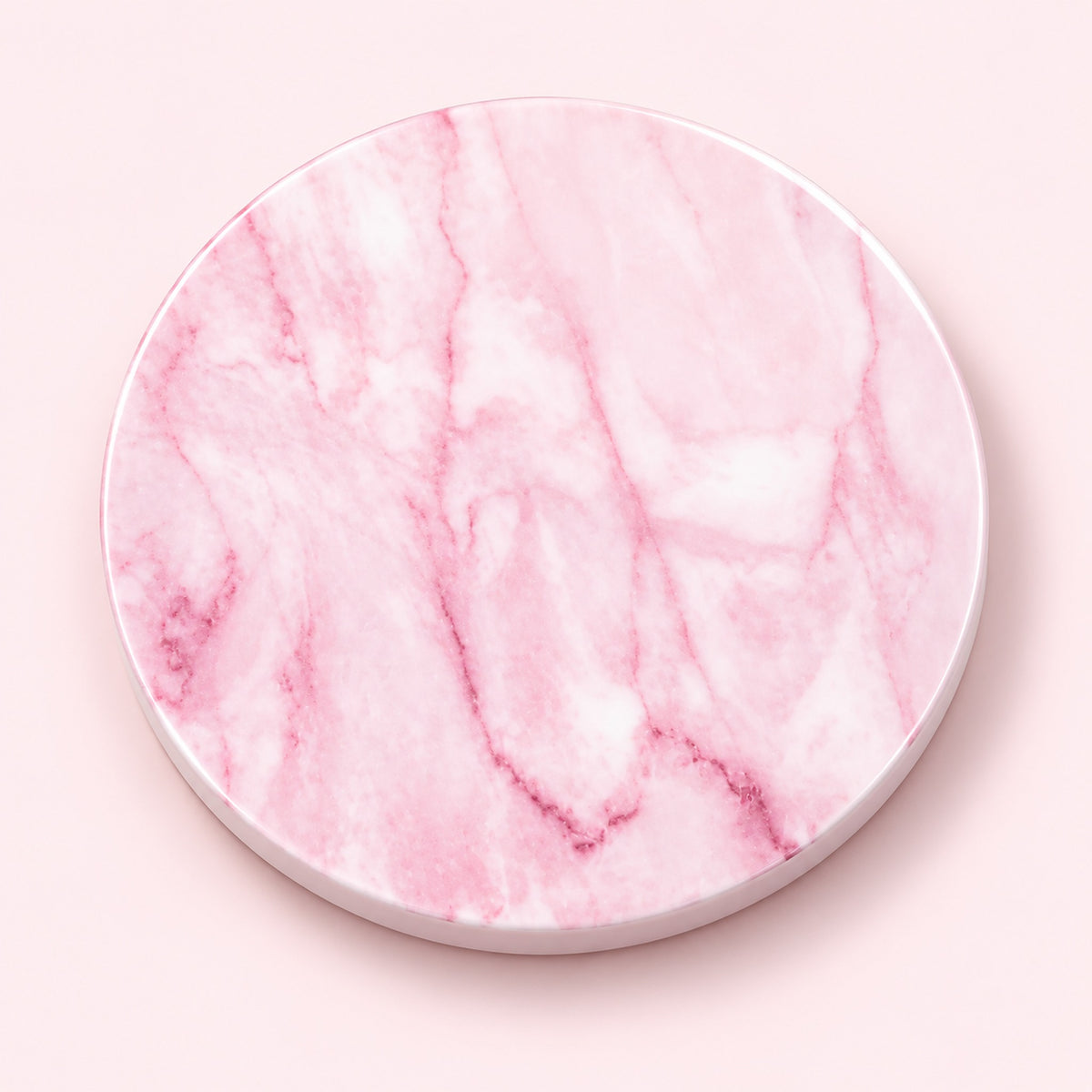 A round pink marble-patterned coaster with a white rim, shown from a top-down view on a solid pale pink background.