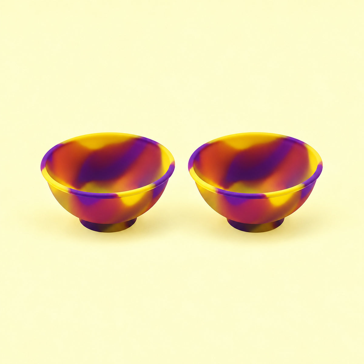Two yellow and purple swirl silicone mini bowls, open tops and pedestal bases.
