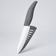 A kitchen knife with a matte gray handle and a silver blade, shown floating against a light gray studio background.