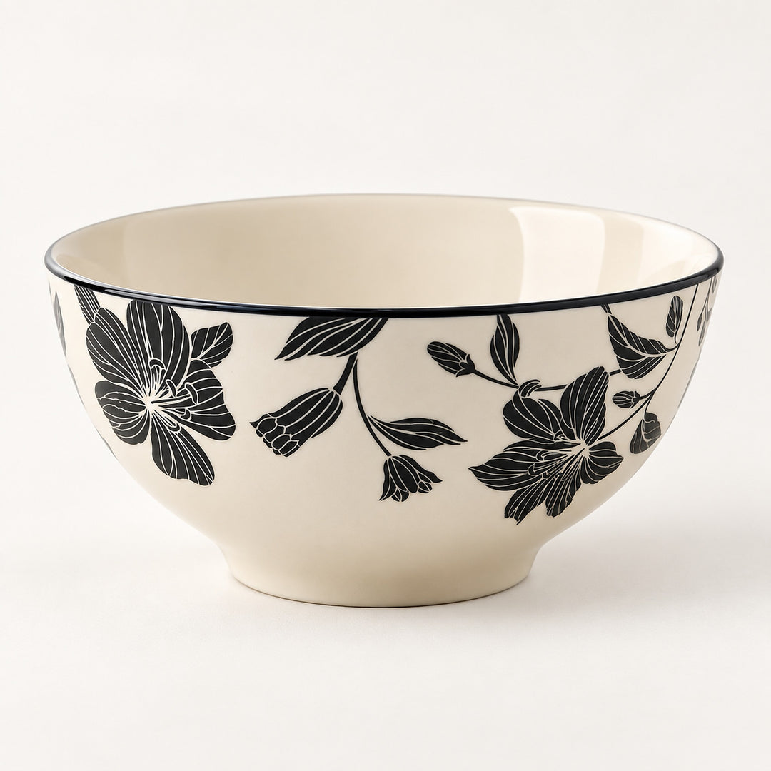 An off-white ceramic bowl featuring a black floral pattern on the exterior and a thin black rim, photographed against a clean white background.