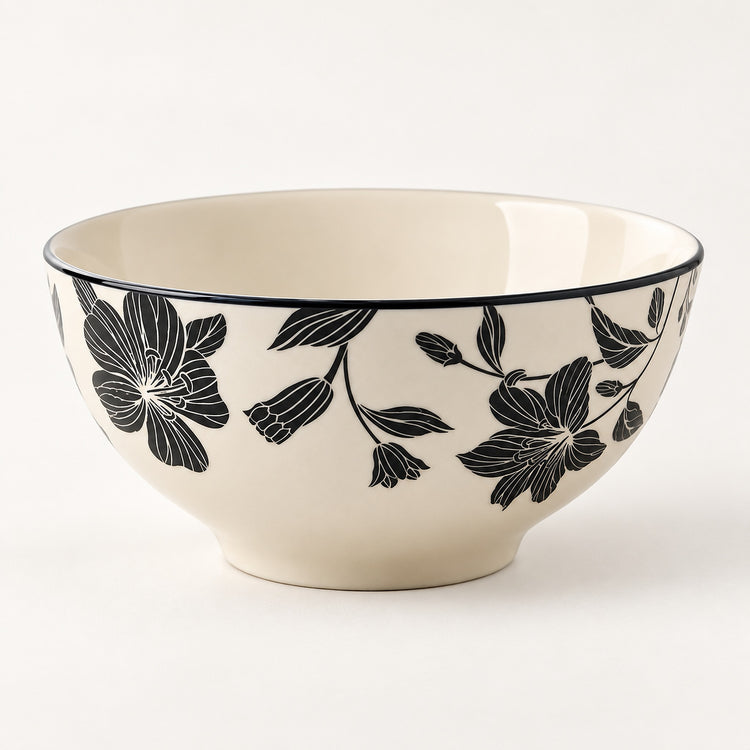 An off-white ceramic bowl featuring a black floral pattern on the exterior and a thin black rim, photographed against a clean white background.