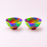 Two rainbow swirl silicone mini bowls, open tops and pedestal bases.
