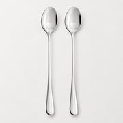 Two polished stainless steel spoons with long handles, shown vertically side-by-side on a clean, light gray background.