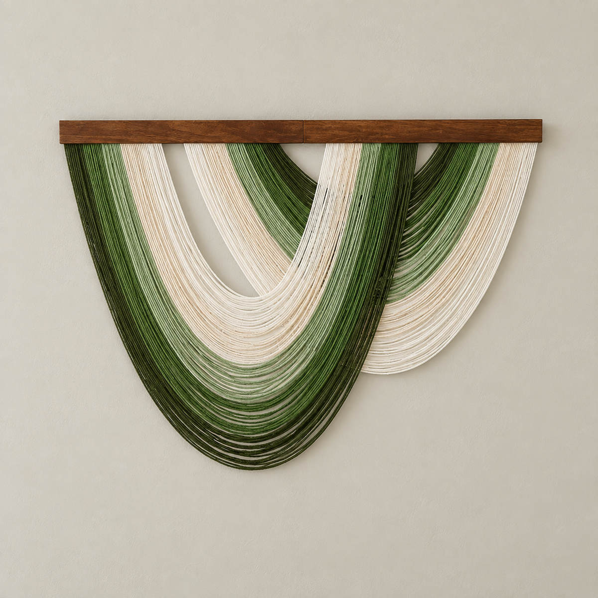A modern wall hanging sculpture featuring layered, curved strands in shades of forest green and cream, suspended from a dark brown wooden bar against a neutral beige wall.