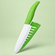 A small kitchen knife with a bright green handle and a matching green sheath, shown on a light green studio background.