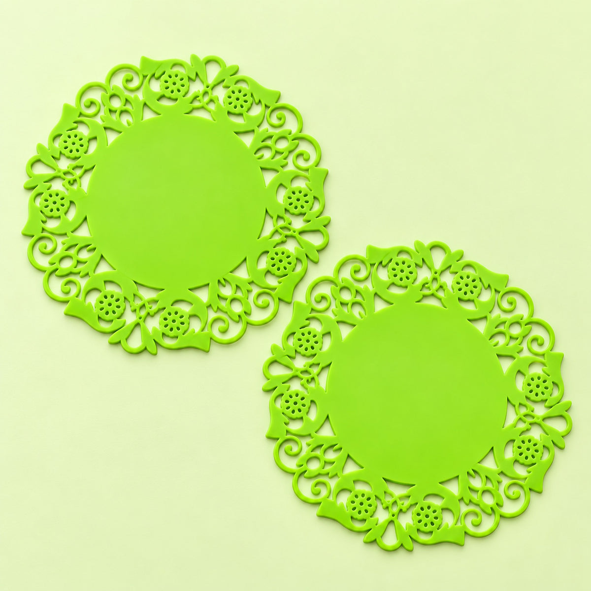 Two lime-green floral round silicone coasters, 9.5 cm diameter.