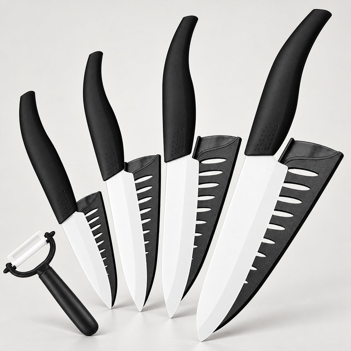A 5-piece kitchen knife set with black handles and white blades, shown with matching black sheaths and a black-handled peeler on a light gray background.