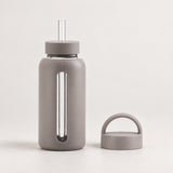 Gray 800 ml glass bottle with silicone sleeve, wide straw and spare loop lid.