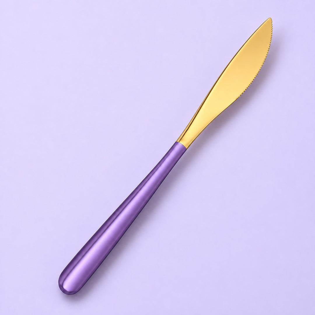 One purple and gold dinner knife on a soft studio background.