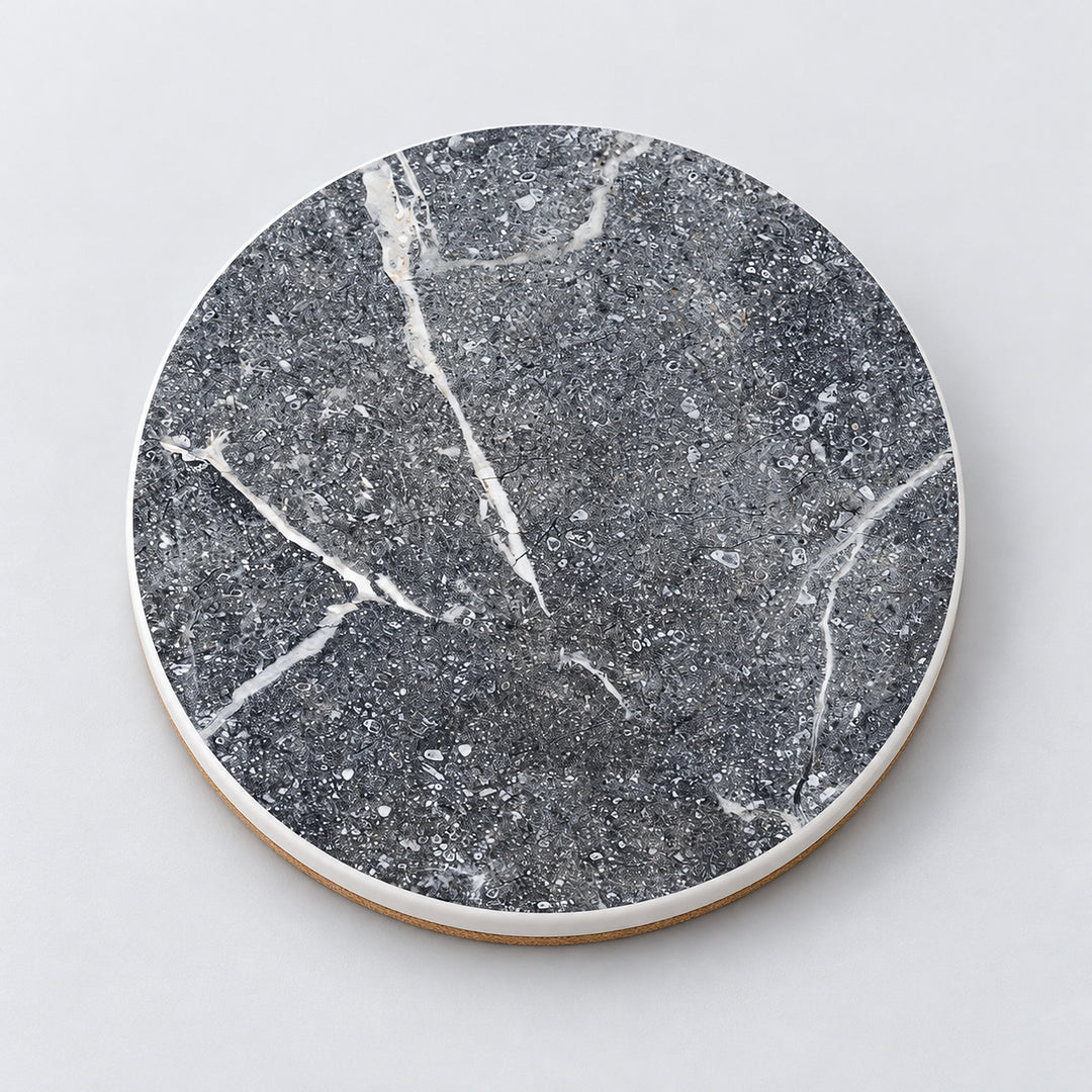 One speckled gray and white marble printed ceramic coaster on a light studio background.