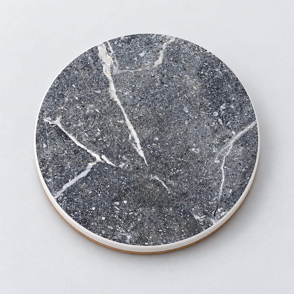 One speckled gray and white marble printed ceramic coaster on a light studio background.