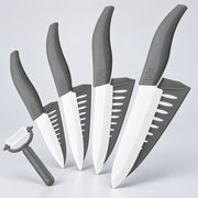 A 5-piece kitchen knife set with white blades and gray handles, arranged diagonally on a light gray background, with a matching gray peeler in the foreground.