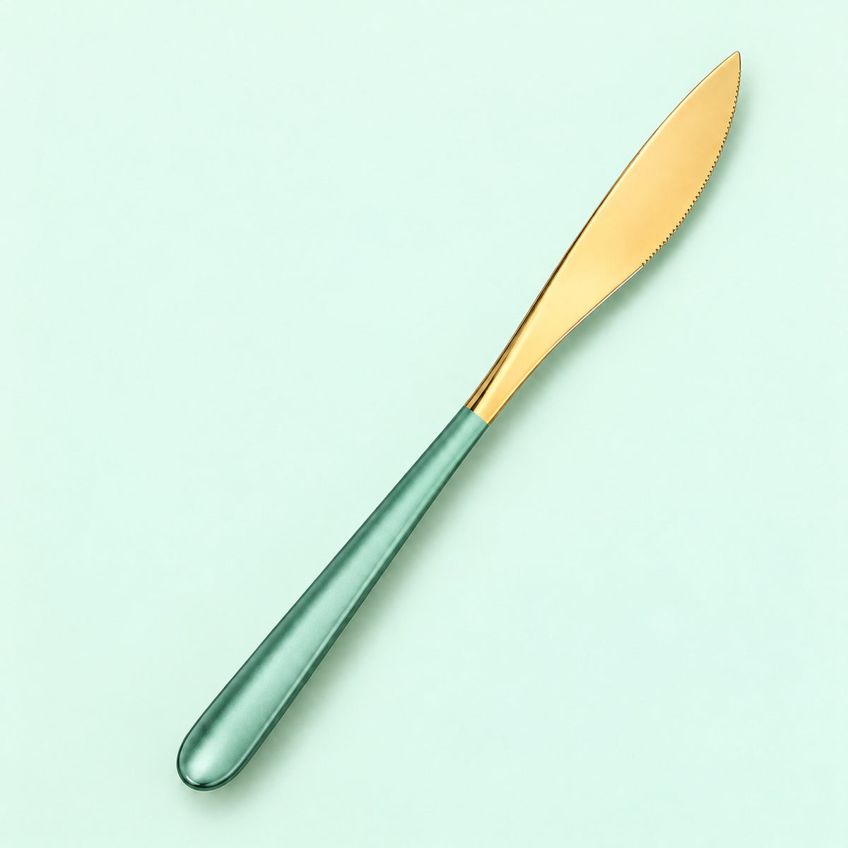 One mint and gold dinner knife on a soft studio background.