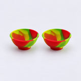 Two red green and yellow swirl silicone mini bowls, open tops and pedestal bases.