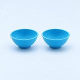 Two blue silicone mini bowls, open tops and pedestal bases.