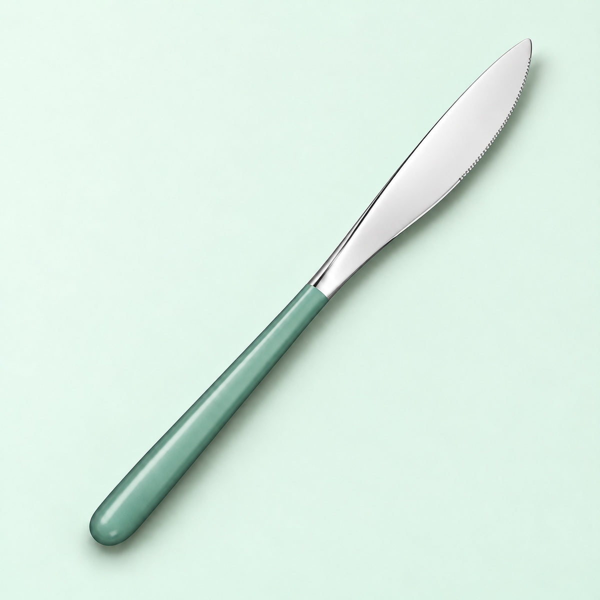 One mint and silver dinner knife on a soft studio background.