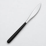 One black and silver dinner knife on a soft studio background.