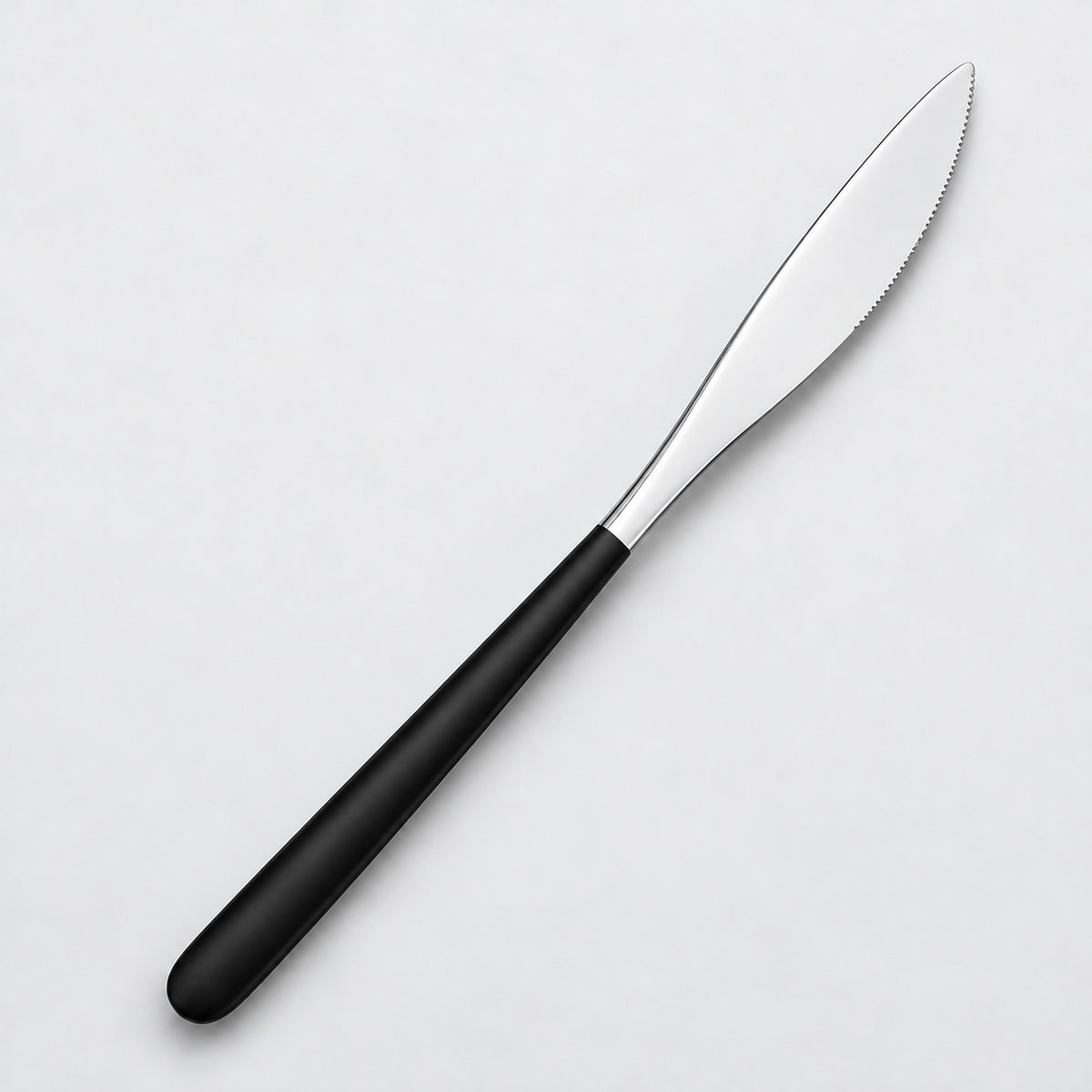 One black and silver dinner knife on a soft studio background.