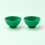 Two dark green silicone mini bowls, open tops and pedestal bases.