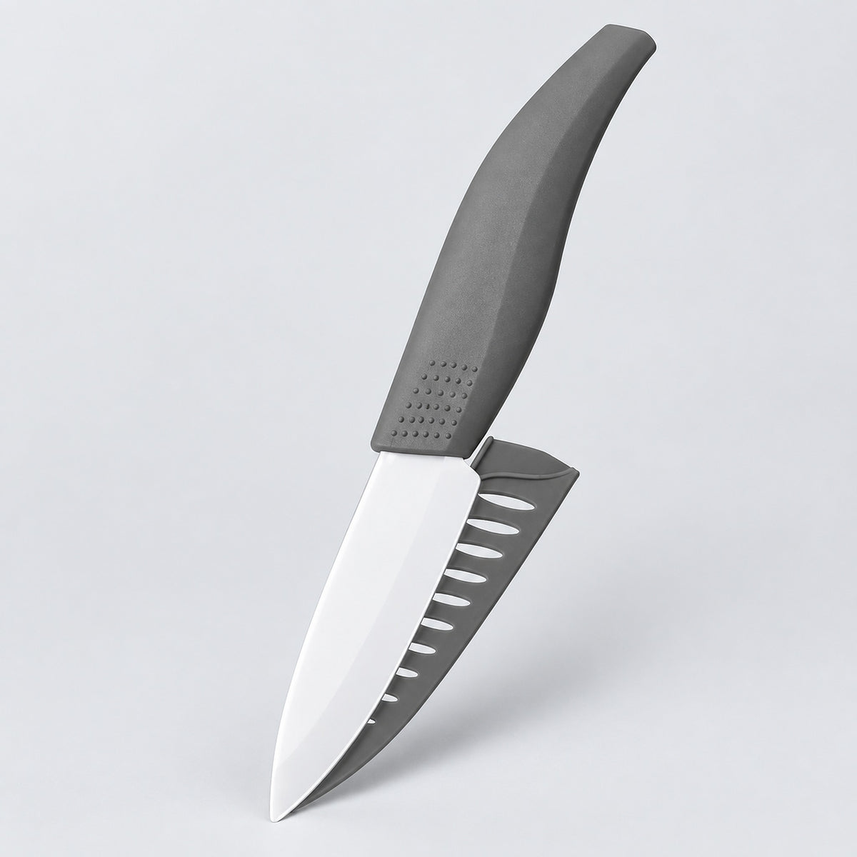 A kitchen knife with a matte gray handle and a silver blade featuring a serrated gray edge, shown floating against a light gray background.