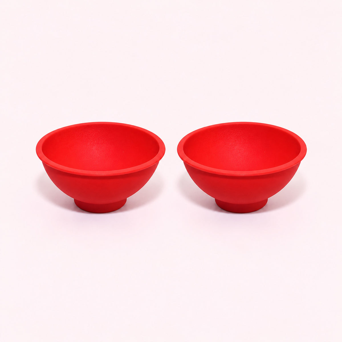 Two red silicone mini bowls, open tops and pedestal bases.