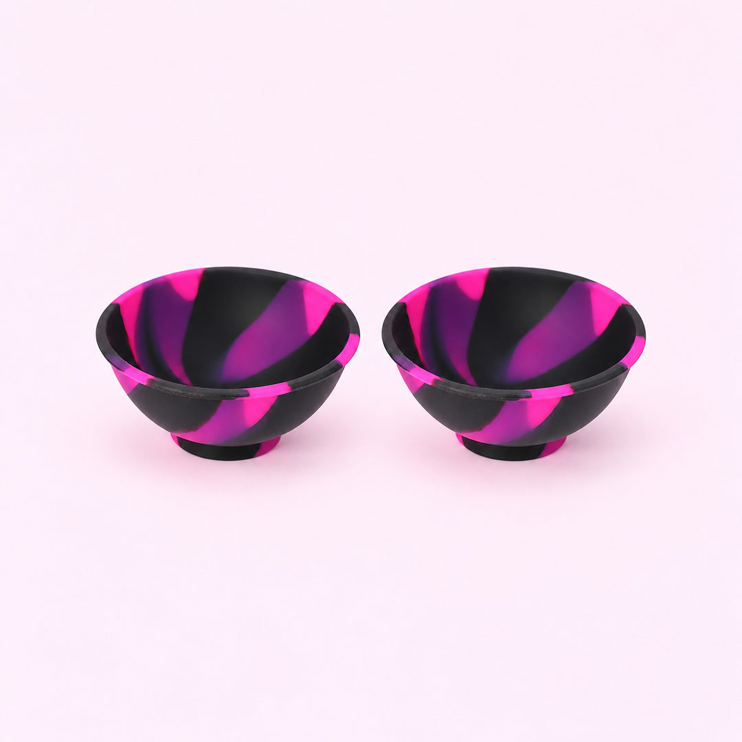 Two black pink and purple swirl silicone mini bowls, open tops and pedestal bases.