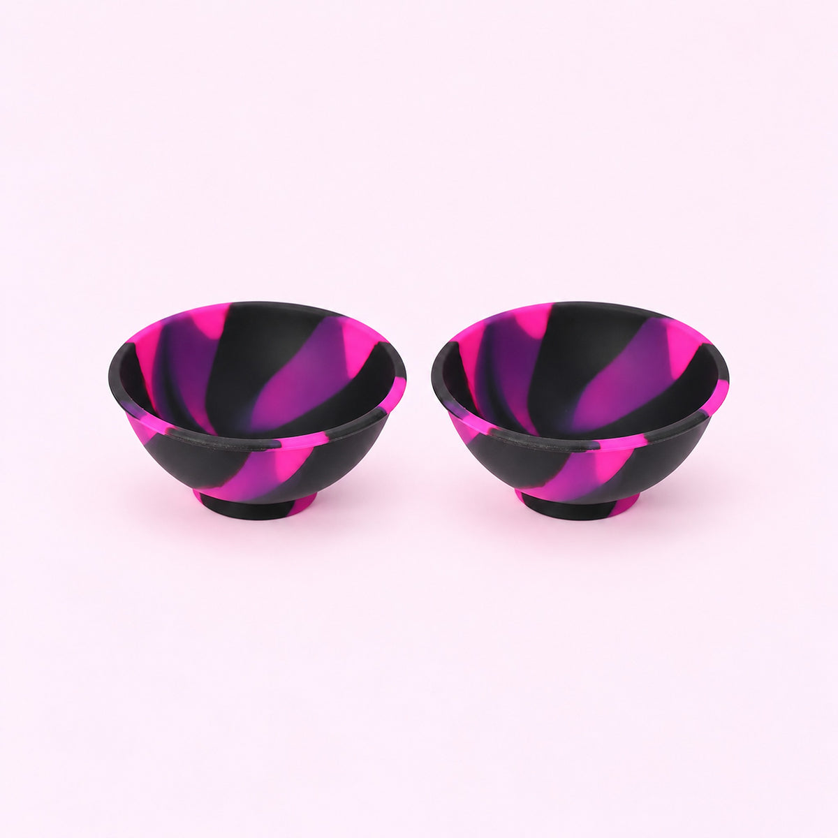 Two black pink and purple swirl silicone mini bowls, open tops and pedestal bases.