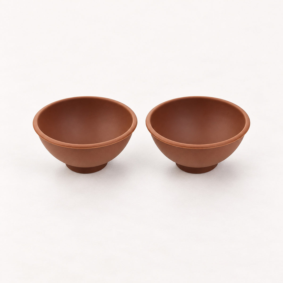 Two coffee brown silicone mini bowls, open tops and pedestal bases.