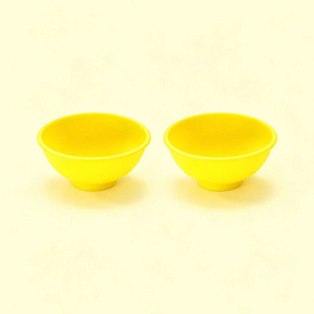 Two yellow silicone mini bowls, open tops and pedestal bases.