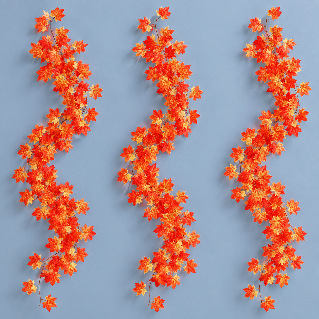 Three artificial maple leaf garland strands hung together on a pale blue wall