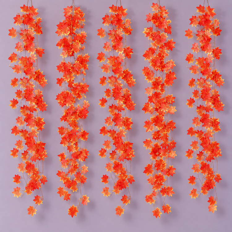 Five red and gold maple leaf vine strands hanging side by side on a lilac wall