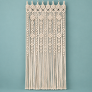 Cream macrame door curtain with a diamond and lattice header on a teal wall