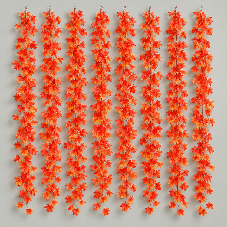 Eight artificial fall leaf garland strands hung together on a pale gray wall