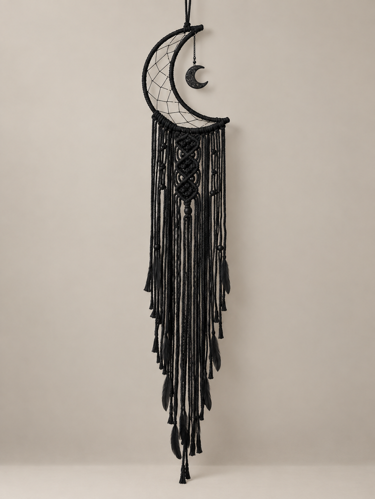Charcoal macrame moon dream catcher unlit against a pale studio wall