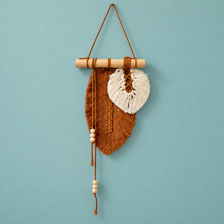 Rust and cream macrame leaf with a beaded tassel cord on a teal background