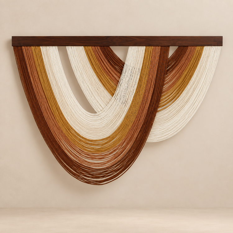 Rust, mustard and cream nested arc wall hanging on a sand colored wall