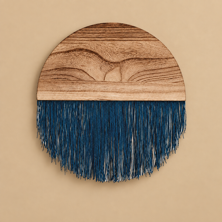 Deep indigo fringe under a grained wood half disc forming a circle on a sand wall