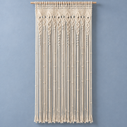 Cream macrame door curtain with an eye and diamond header on a blue wall