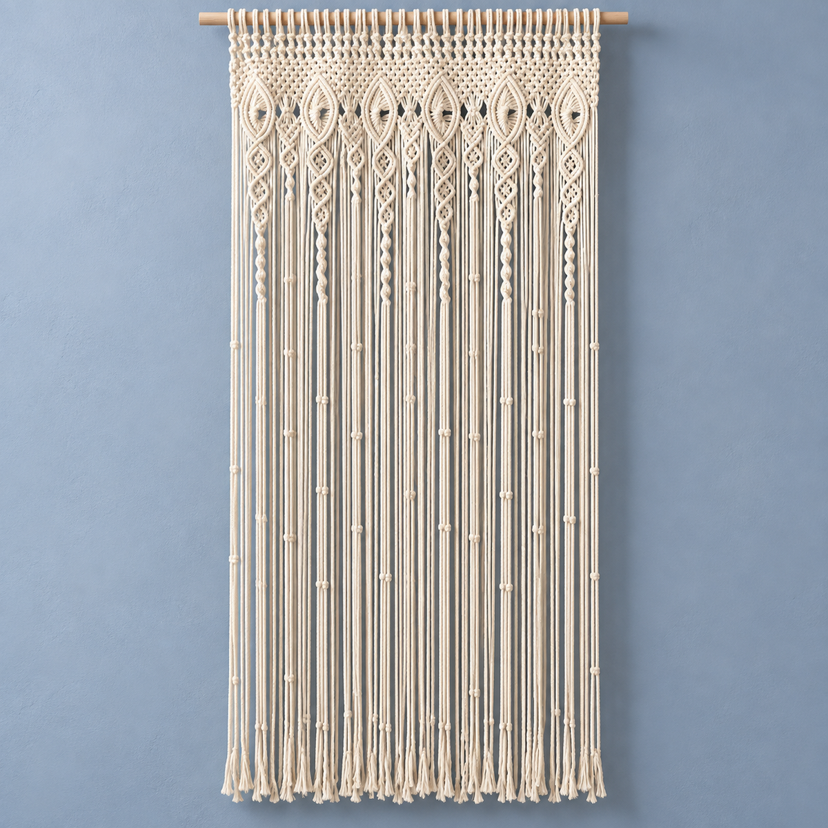 Cream macrame door curtain with an eye and diamond header on a blue wall