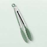 Green silicone-tipped kitchen tongs with a silver metal hinge and a hanging loop, shown on a pale mint green background.