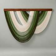Olive and cream nested arc wall hanging under a dark batten on a cream wall