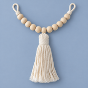 Single beaded cotton curtain tie back with a thick cream tassel on a blue background